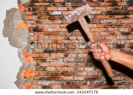 breaking brick wall with hammer