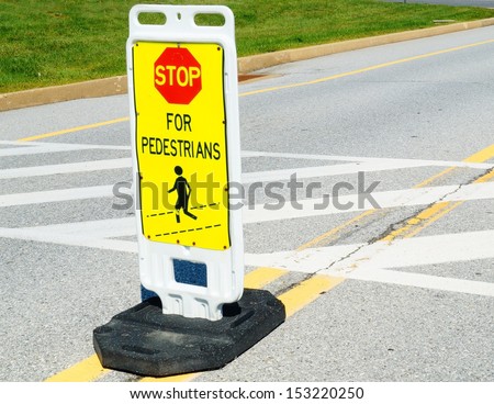 Stop Sign at Pedestrian Crossing.  A stop for pedestrians sign marks a crosswalk in the street.
