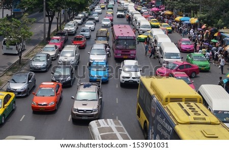 BANGKOK - MARCH 2013: Cars, buses, taxis and people crowd a busy street at Chatuchak market Bangkok.  Chatuchak (or Jatujak) is the largest market in Thailand and the world\'s largest weekend market.