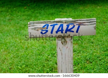 Start Sign New Beginning.  A weathered wooden start sign marks the beginning of something new.