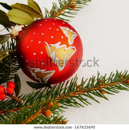 Christmas Tree Ornament. Red and gold Christmas tree ornament and holly berry on fresh snow background
