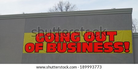 Going Out of Business.  A going out of business banner on a bankrupt storefront.