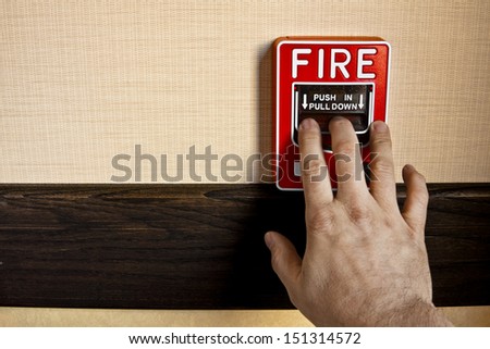 Many Buildings Have Manual Fire Alarm Boxes. A Man'S Hand Is On The Alarm Lever To Activate It. There Is Room For Your Copy On The Left Side.