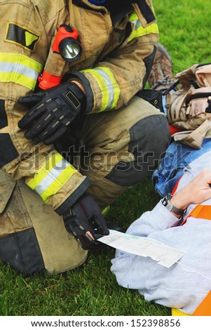 In any disaster or accidents victims receive medical attention. Medical tags are attached to them to track status. This fireman is checking on the injured status and card.