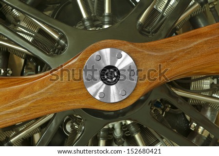 This is a close up view of a vintage airplane engine with a wood propeller prop.