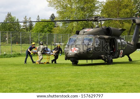 EUGENE, OREGON USA  May 2, 2012: In Eugene, OR the local Emergency Services and National Guard work in a disaster drill. The firemen carry an injured person on a gurney to the helicopter.