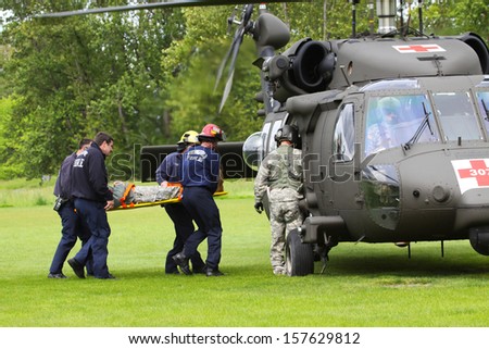 EUGENE, OREGON, USAÂ?Â? May 2, 2012: In Eugene, OR the local Emergency Services and National Guard work in a disaster drill. The firemen carry an injured person on a backboard to the helicopter.