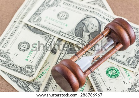 Hourglass on background of dollar
