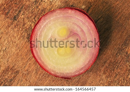 Large onion, cut in half on a wooden floor.