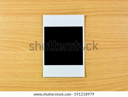 Blank photo frames on wooden background.