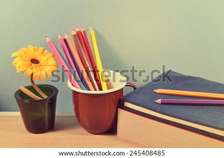 Crayon, flower and the books on table