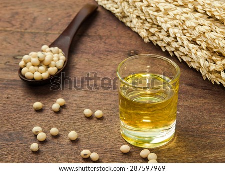 Soy oil and soy bean on wooden table.