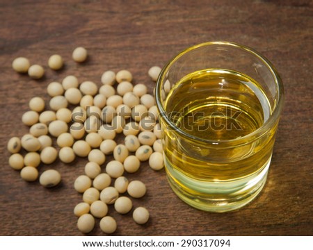 Soy oil and soy bean on wooden table.