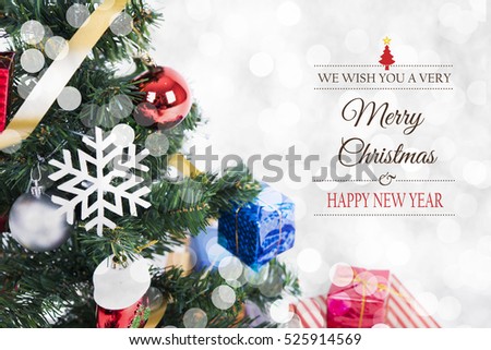 Christmas decorative with gift box and snowflake on christmas tree and Merry Christmas and Happy New Year 2017 text on bokeh light background.