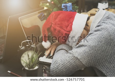 business woman with santa hat sleeping on desk office after christmas party and happy new year.
