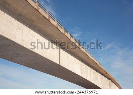 Concrete traffic bridge span and blue sky.