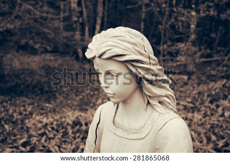 Angel statue portrait in wooded setting. Toned grunge look.