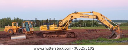 FOX HARBOUR, CANADA - AUGUST 11, 2015: Komatsu is a Japanese corporation manufacturing industrial and military equipment. John Deere is an American company manufacturing industrial and lawn equipment.