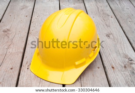 Yellow Hard hat on wooden boards.