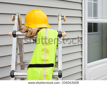 Stepladder with hardhat, work gloves, and reflective safety vest