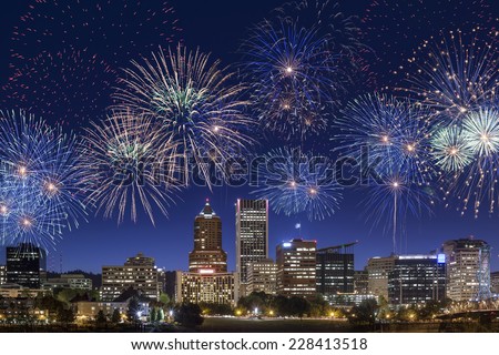 Straight view on Portland's downtown buildings and skyscrapers in an early night with fireworks on the sky
