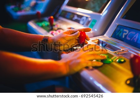 Detail on Hands with Arcade Joystick Playing Old Arcade Video Game