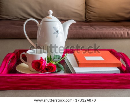 Cup of coffee with red roses in modern living room