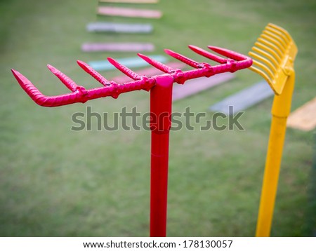 Colorful garden (steel rake) accessories  on green grass background