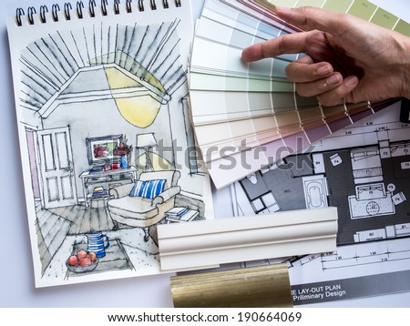 Interior designer's hand working with illustration sketch material and color samples Interior designer's hand working with illustration sketch material and color samples
