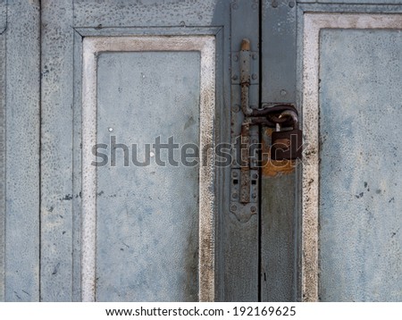 Asian ruin blue door locked with a rusty Padlock and latch