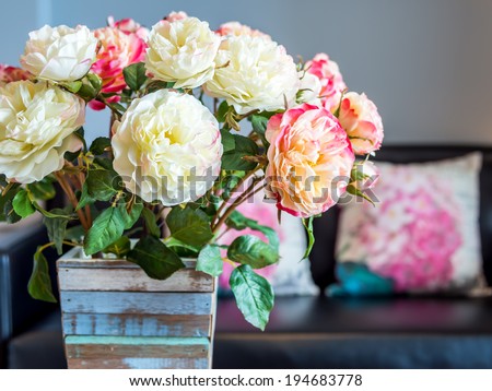 Modern interior room decorated with artificial flowers in rustic wooden vase