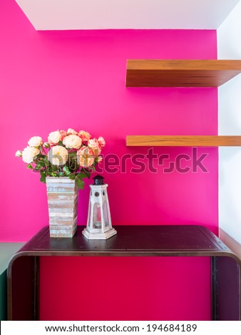 Magenta modern interior wall with artificial flowers in rustic wooden vase