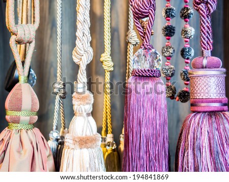 Detail of decorative tassel for curtains with crystal and cord hanging in a retail store