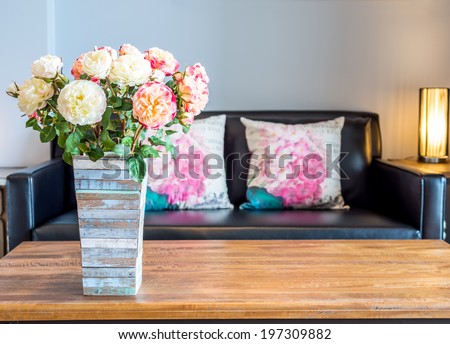 Modern interior room decorated with artificial flowers in rustic wooden vase