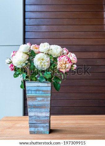Artificial canation  flowers with rustic wooden vase in modern interior room