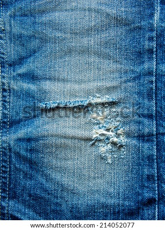 Closeup of blue torn denim jeans texture