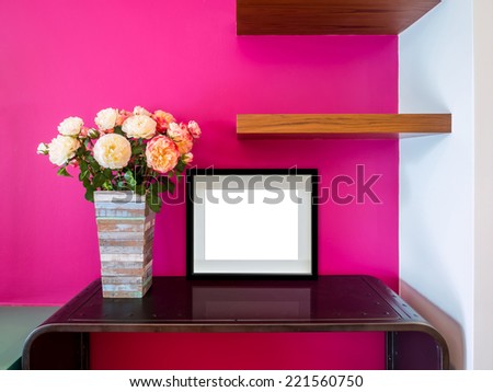 Modern interior wall with artificial flowers vase and blank picture frame