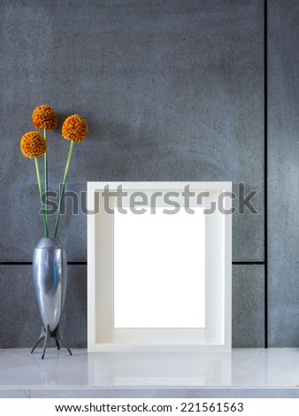Modern interior wall with vase of flowers and blank picture frame