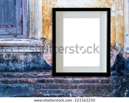 Blank black picture frame on abstract rustic cracked concrete brick wall background