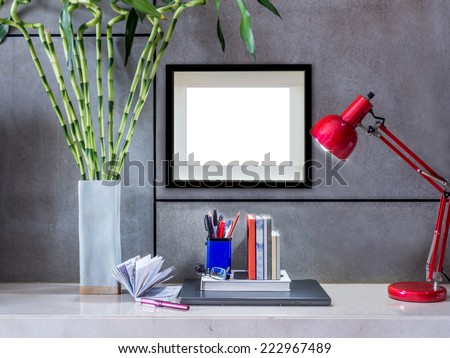 Modern office desk with laptop, flowers vase and blank  picture frame