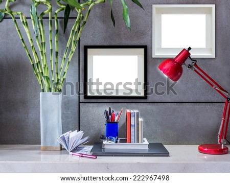 Modern office desk with laptop, flowers vase and blank  picture frames