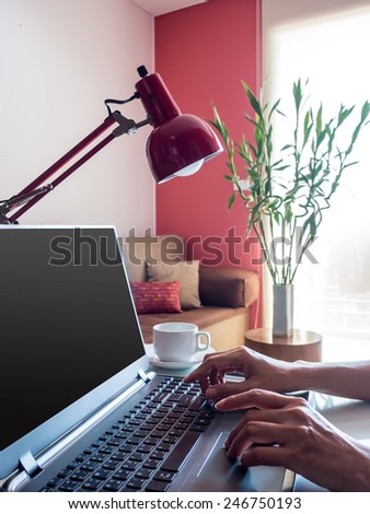 Hands working over laptop  on desktop in modern office background