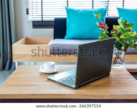 Modern interior Living room with laptop on table top/ sofa background