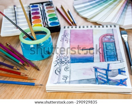 Architectural  sketchbook, watercolor paints, color-pencils for painting on wooden table background