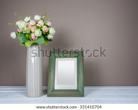 Interior still-life, photo frame, flower vase on wooden table top/ home improvement concept