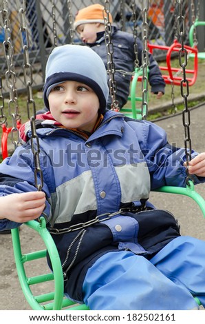 Children on chain swing merry-go-round at funfair.
