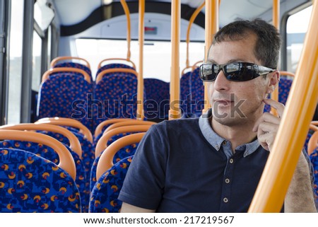 Man passenger siting on city bus, traveling by modern public transport.