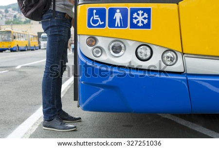 Detail of a modern city public transport  bus and a passenger getting on.