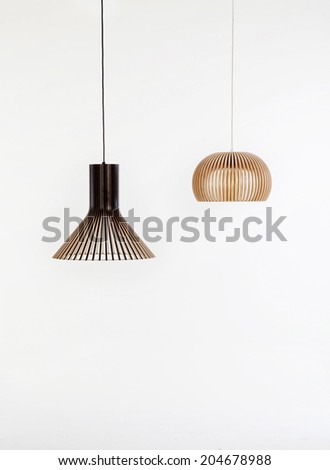 two modern wooden chandeliers on white backgrounds