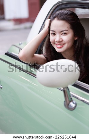 Young asian lady in a vintage car